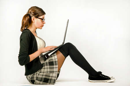 The girl with glasses working on a laptopの写真素材