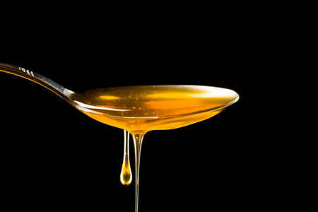 Spoonful of honey on the black background