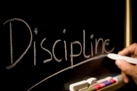 The concept of discipline, the inscription on the background of a black chalkboardの写真素材