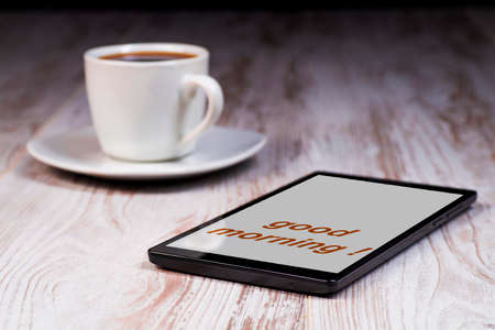 The concept of digital information transfer, new media, a tablet with a cup of coffeeの写真素材