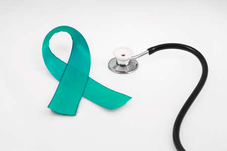 Health protection concept, ovarian cancer, stethoscope and turquoise ribbon on a white backgroundの写真素材