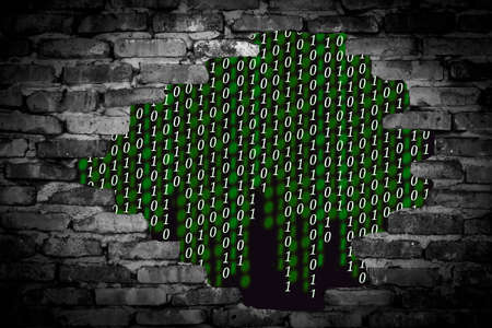 Binary code in the wall breach on a black backgroundの写真素材