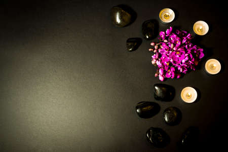 bouquet of purple orchids, candles and stones isolated on a black backgroundの写真素材