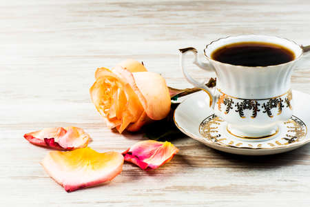 Bright red rose on a background of a cup with an ornament on a white backgroundの写真素材