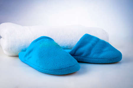 Blue slippers on a white towel on a white-blue backgroundの写真素材