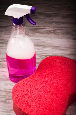 Items for cleaning, red sponge on the background of the spray with violet liquidの写真素材