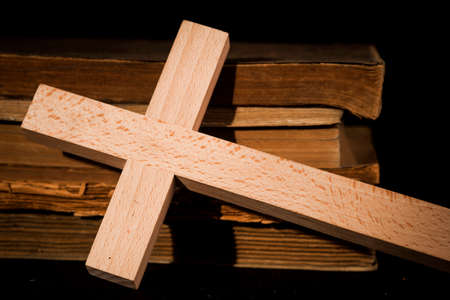 Crucifix against the background of books on old boardsの写真素材
