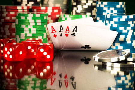 Gambling concept - Cards and dice on a background of chips with a reflection