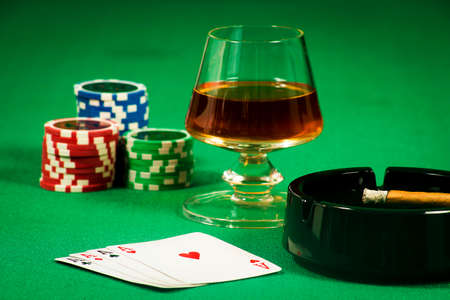 The concept of gambling, playing cards and chips with a glass of cognac and a cigarの写真素材