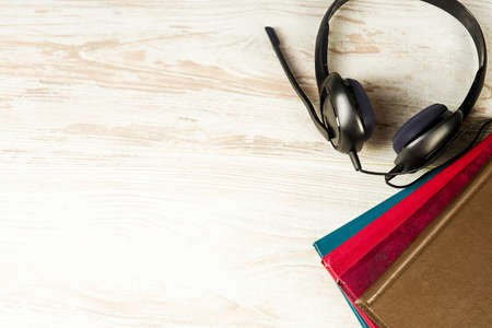 Concept of audiobooks, headphones with microphone and books on vintage backgroundの写真素材