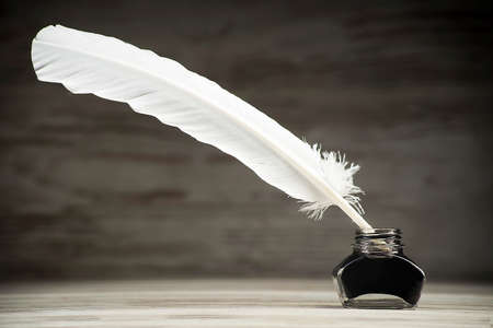 Writing concept, pen and inkwell on a dark backgroundの写真素材