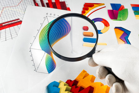 Magnifier on a background of colorful graphical charts