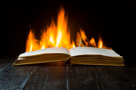 An open hardback book with flames in the backgroundの写真素材