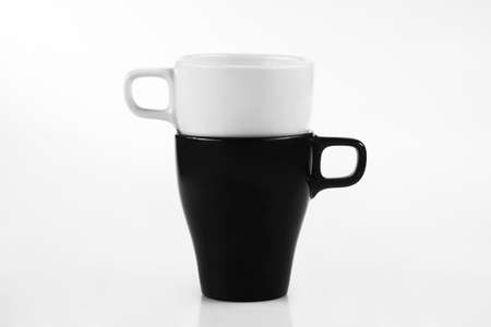 White cup and black mug isolated on a white backgroundの写真素材
