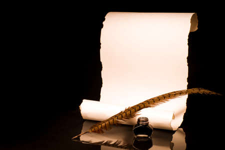 Unrolled papyrus scroll with inkwell and bird featherの写真素材