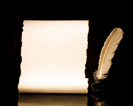 Unrolled papyrus scroll with inkwell and bird featherの写真素材