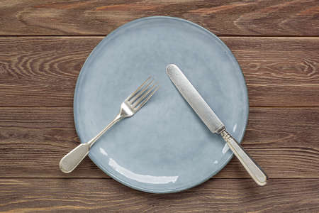 Ceramic plate and cutlery on a wooden worktopの写真素材
