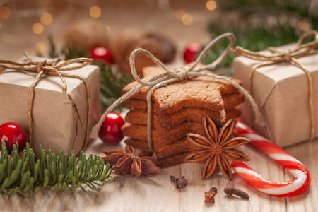 Christmas - a composition made of homemade gingerbreads, nuts, anise, cinnamon sticks, goats, dried oranges, green fir, bells and giftsの写真素材