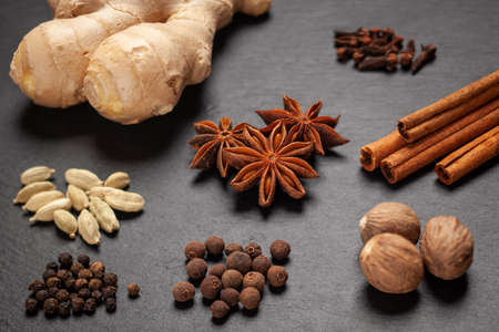 Gingerbread spices on slate - star anise, cinnamon, cloves, nutmeg, ginger, cardamom, black pepper, allspiceの写真素材