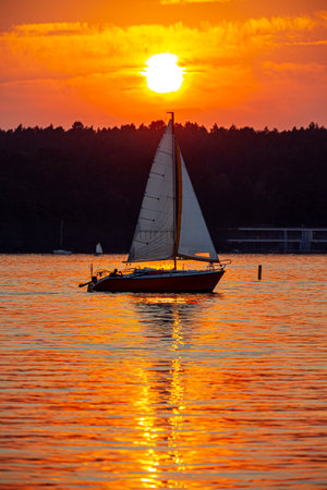 Sailboat in the background of the setting sun on the lake in Olsztyn - Warmia and Masuria, Poland, Europeの写真素材