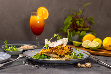 Carp fillet with pistachio crumble on potato and parsley mousse served with green peasの写真素材