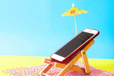 Smartphone on a sunbed on the beach. Holiday without a smartphone conceptの写真素材