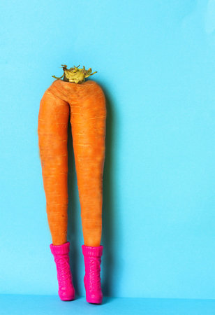 Funny carrot legs with shoes. Health care and beta carotene concept.