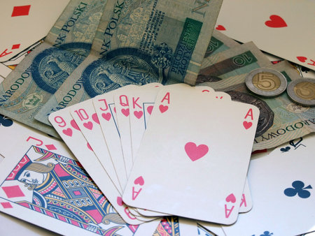 hearts poker and money on playing cards background