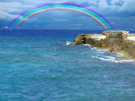 Rock at the Sea, with beautiful rainbowの写真素材