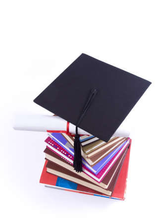 A lot of books, tower made of books with student hat and diploma, against a white backgroundの写真素材