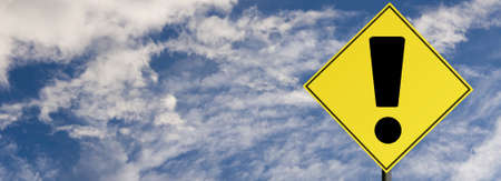 Road sign warning on a cloudy sky backgroundの写真素材