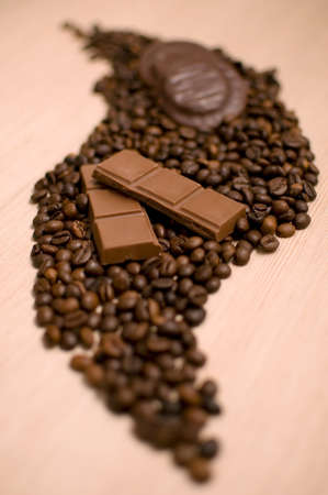 Chocolate and coffee beans in blurred backgroundの写真素材