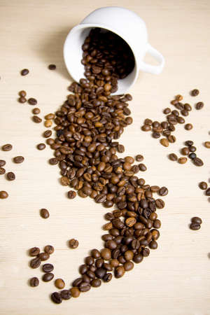 Coffe cup with coffe beans inside and falling outの写真素材