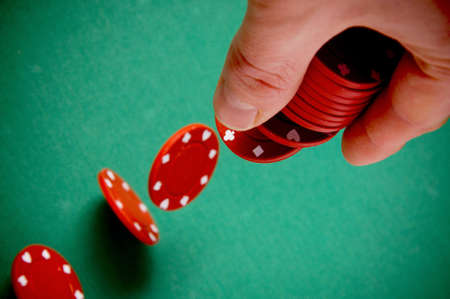 Red gambling chips falling from men hand の写真素材