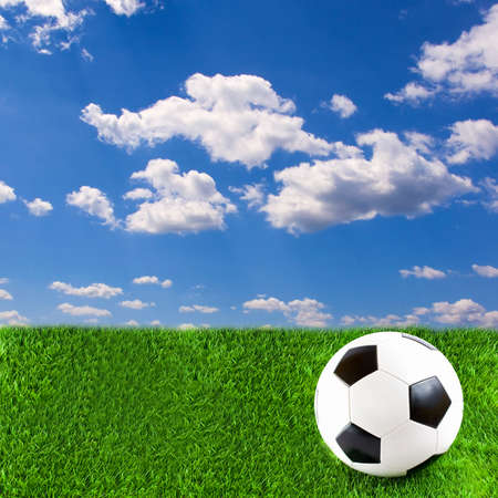 Football on grass, with beautiful sky above itの写真素材