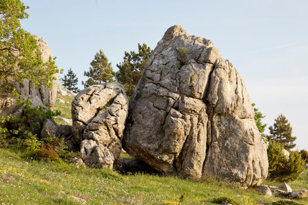 Huge granite boulders on the slope of the mountain against the blue skyの写真素材