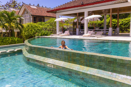 A young girl in a swimming pool in a resort in Uluwatu, Baliのeditorial素材