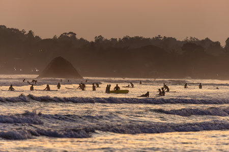 Public town beach in Weligama at sunset with surfers, Sri Lankaのeditorial素材