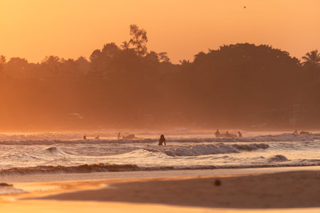 Public town beach in Weligama at sunset with surfers, Sri Lankaのeditorial素材