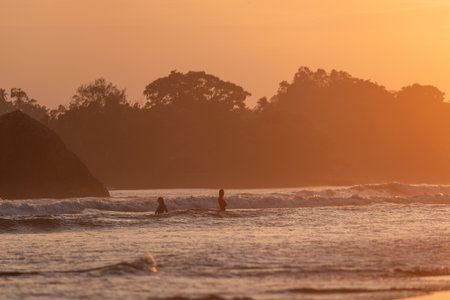 Public town beach in Weligama at sunset with surfers, Sri Lankaのeditorial素材