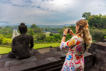 Woman Visitor Among Ancient Buddhist Temple at Borobudur, Indonesiaのeditorial素材