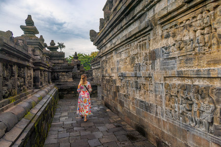 Woman Visitor Among Ancient Buddhist Temple at Borobudur, Indonesiaのeditorial素材
