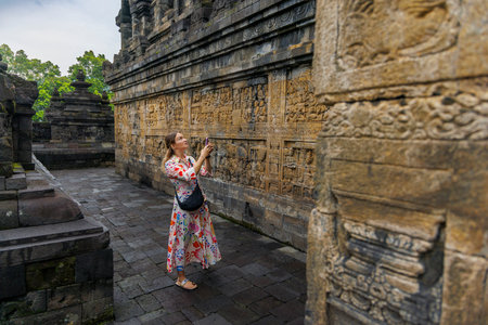 Woman Visitor Among Ancient Buddhist Temple at Borobudur, Indonesiaのeditorial素材