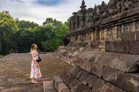 Woman Visitor Among Ancient Buddhist Temple at Borobudur, Indonesiaのeditorial素材