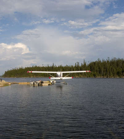float plane that is resting against a dockの写真素材