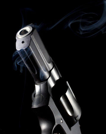 revolver that has smoke coming out on a black background
