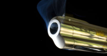 pistol barrel that is still smoking after shootingの写真素材