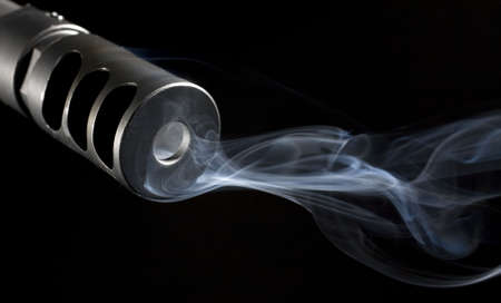 smoke that is pouring from the barrel of a sniper rifleの写真素材