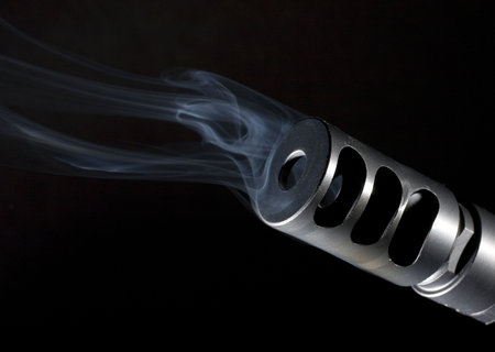 muzzle brake that is on a sniper rifle that is smoking