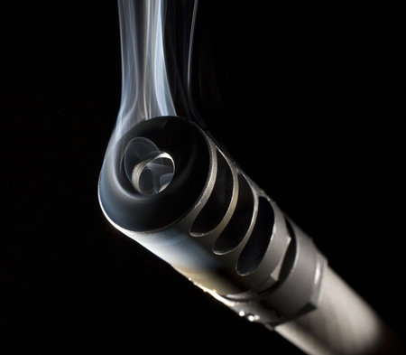 muzzle brake on a high powered rifle that is smoking